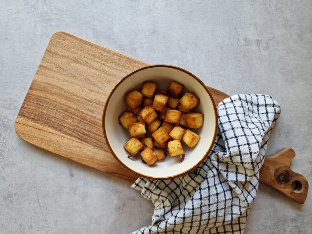 air fryer tofu in a bowl on a chopping board