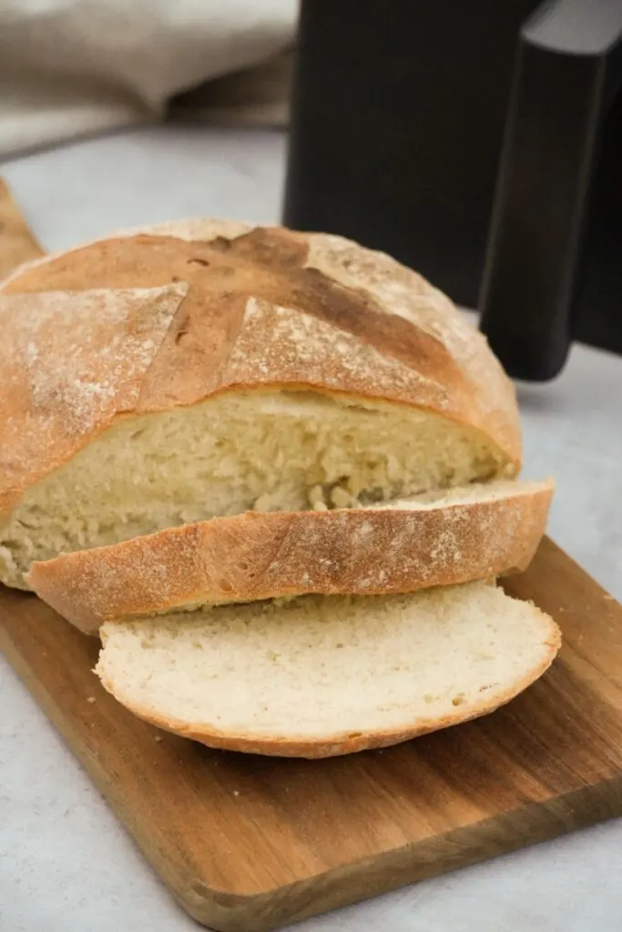 white bread sliced on a chopping board next to an air fryer
