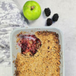 apple and blackberry crumble with bramley apple and blackberry next to it