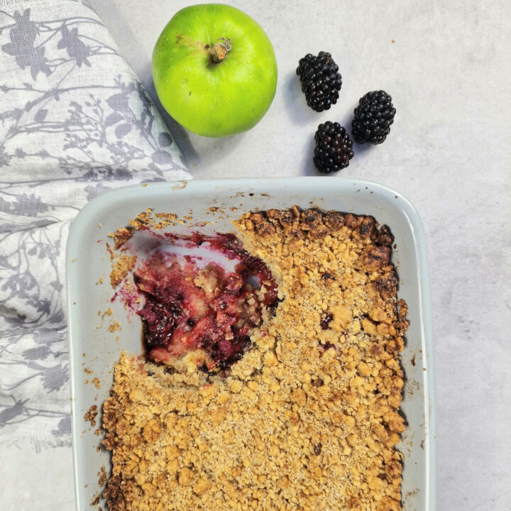 apple and blackberry crumble with bramley apple and blackberry next to it