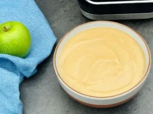 apple and parsnip soup in a bowl next to a Granny Smith apple and a Ninja Soup Maker