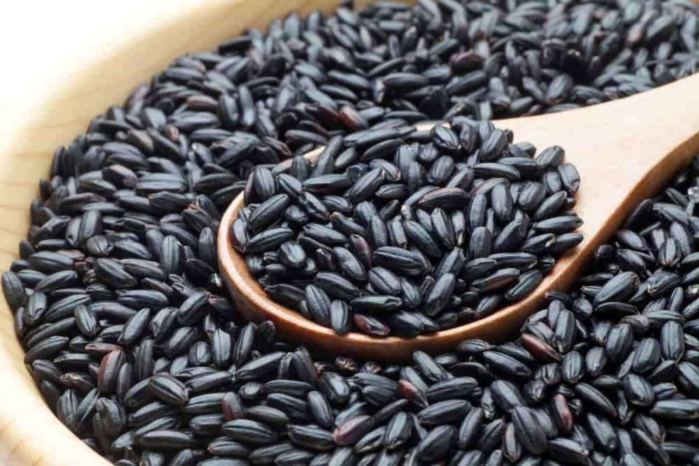 Black rice with wooden spoon, Close-up.