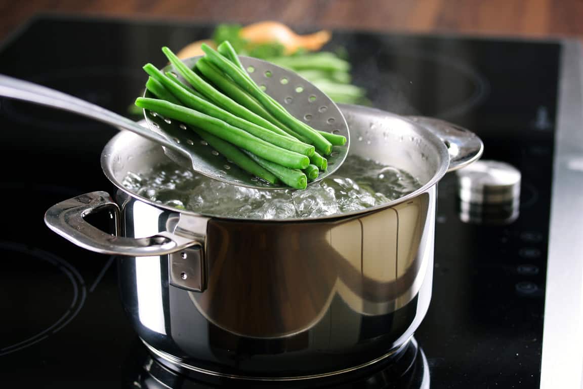 runner beans above saucepan of boiling water for blanching