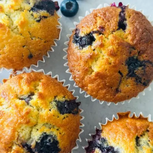 blueberry muffins next to some fresh blueberries