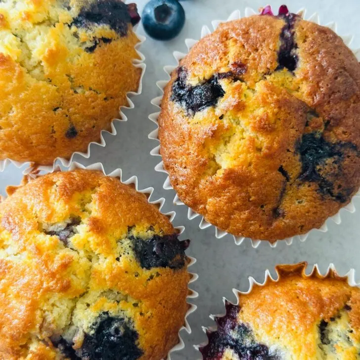 blueberry muffins next to some fresh blueberries