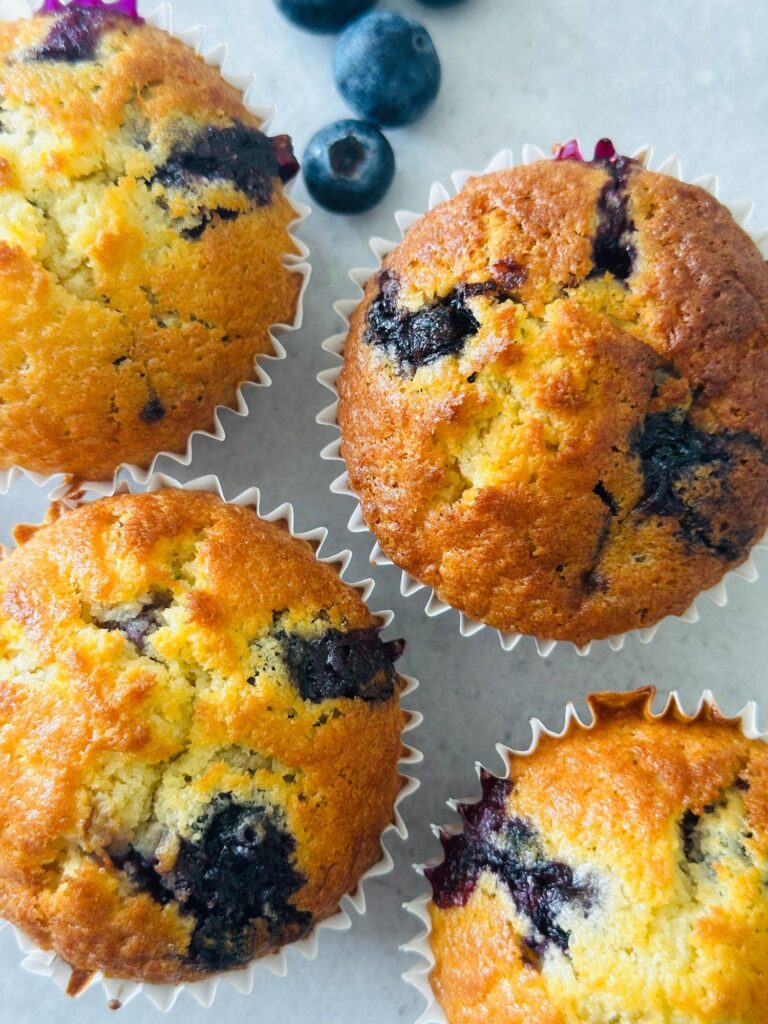blueberry muffins next to some fresh blueberries