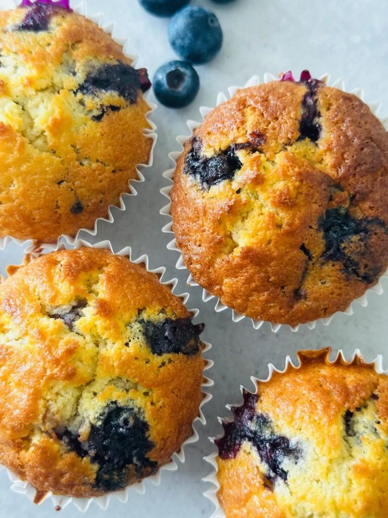 blueberry muffins next to some fresh blueberries