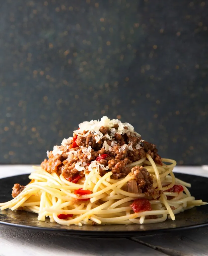 spaghetti bolognese with cheese on top