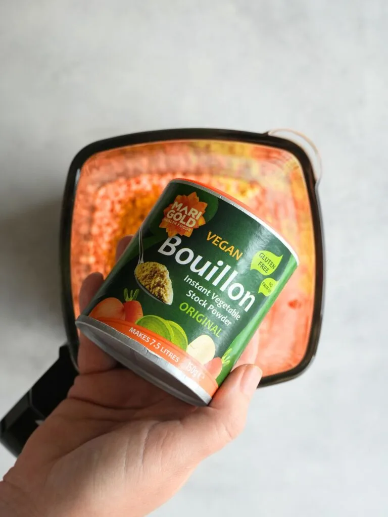 Marigold Bouillon stock held above soup maker jug