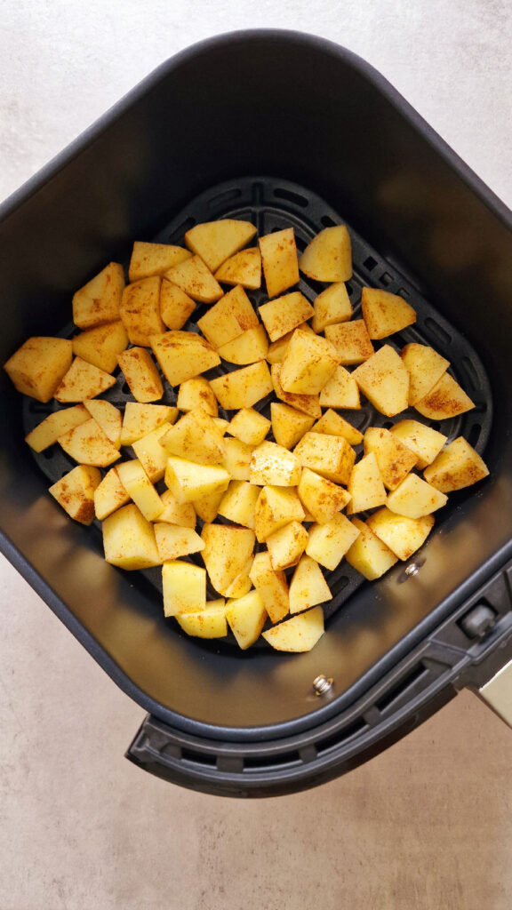 potato cubes in air fryer basket