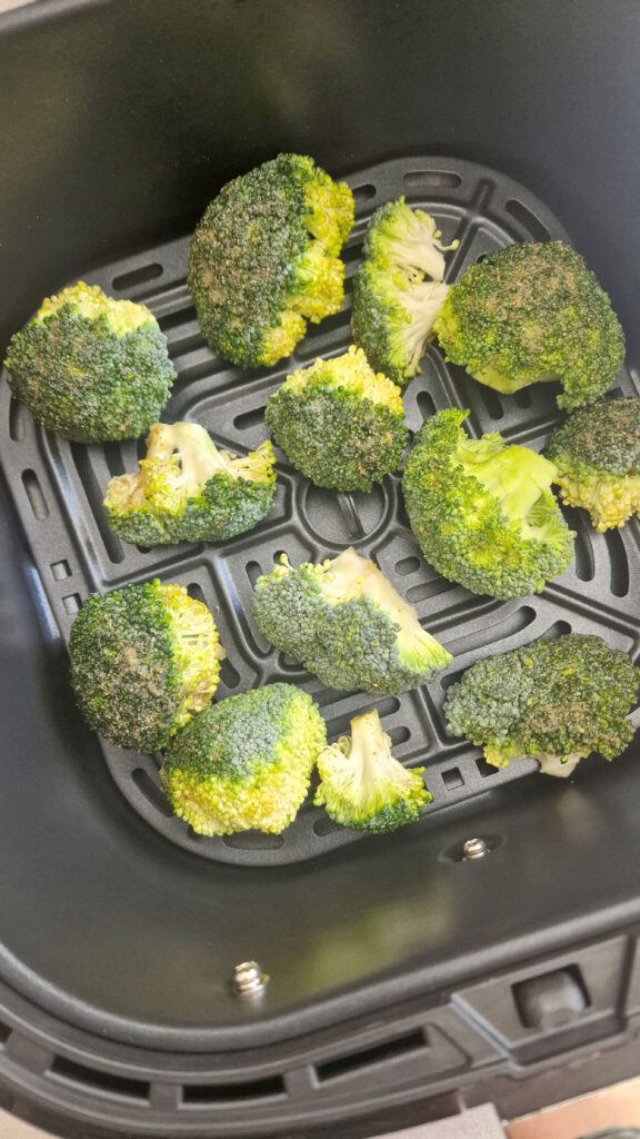 seasoned broccoli in air fryer basket 