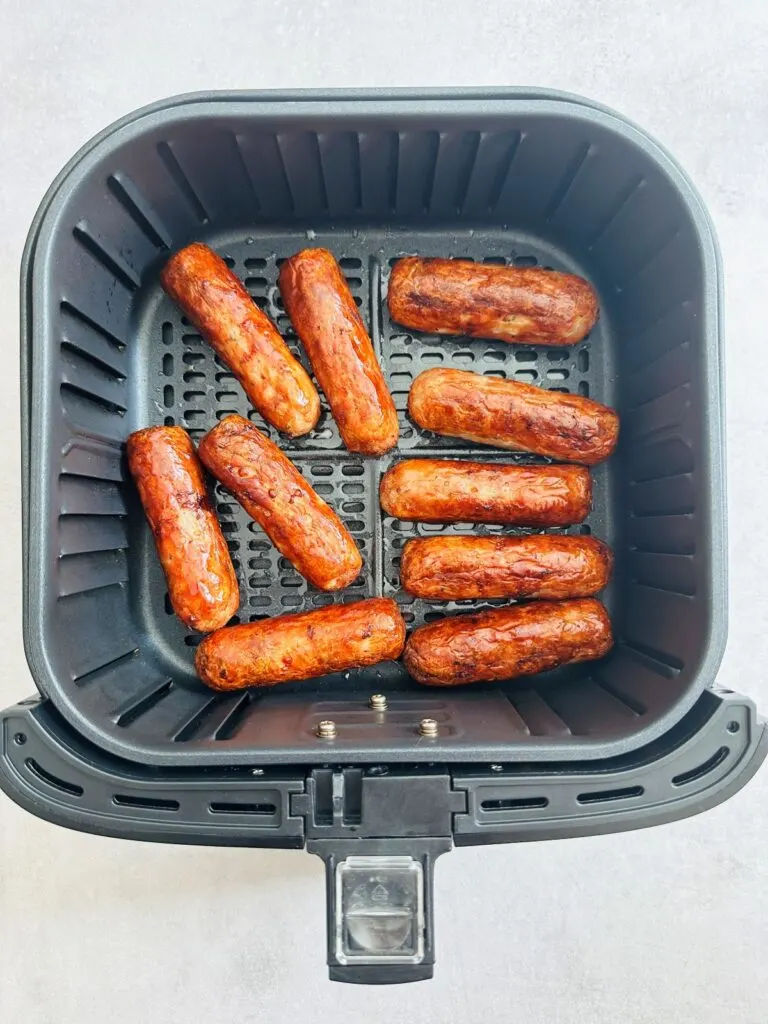 ten browned sausages in air fryer basket