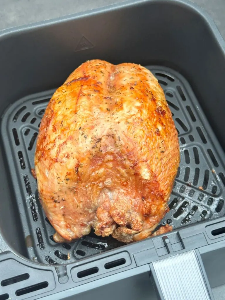 browned turkey crown in air fryer basket
