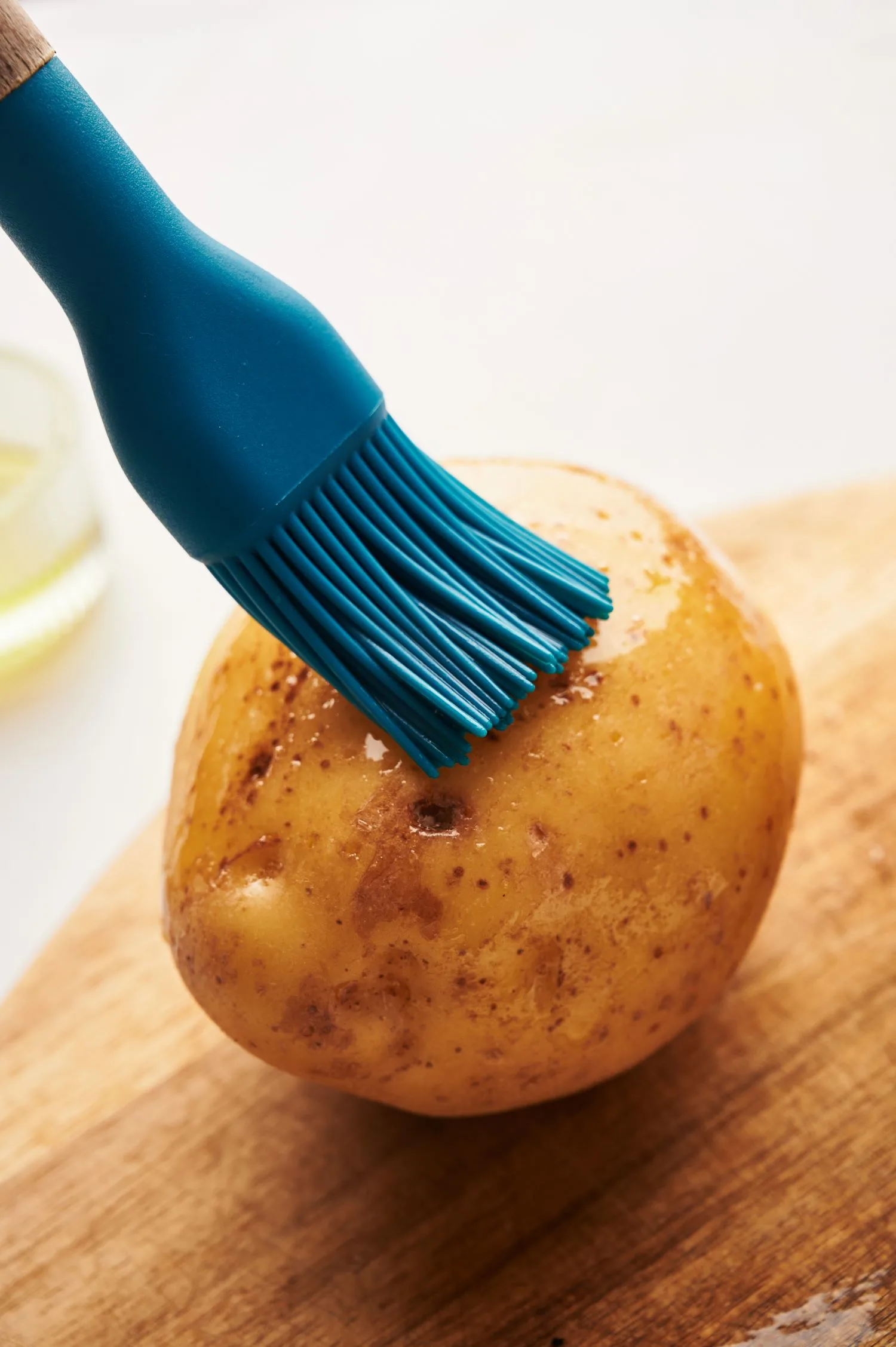 brushing oil on jacket potato