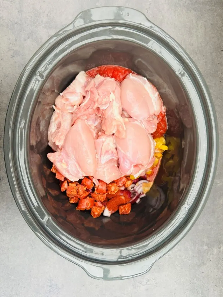 ingredients for chicken and chorizo added to slow cooker