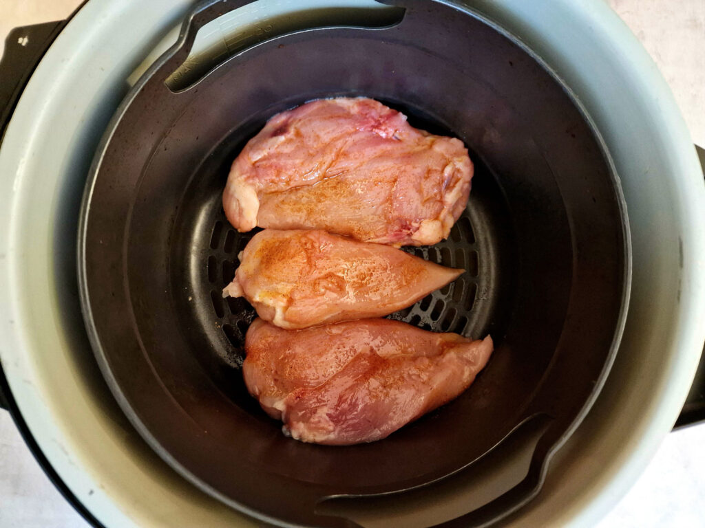 seasoned chicken breasts in an air fryer