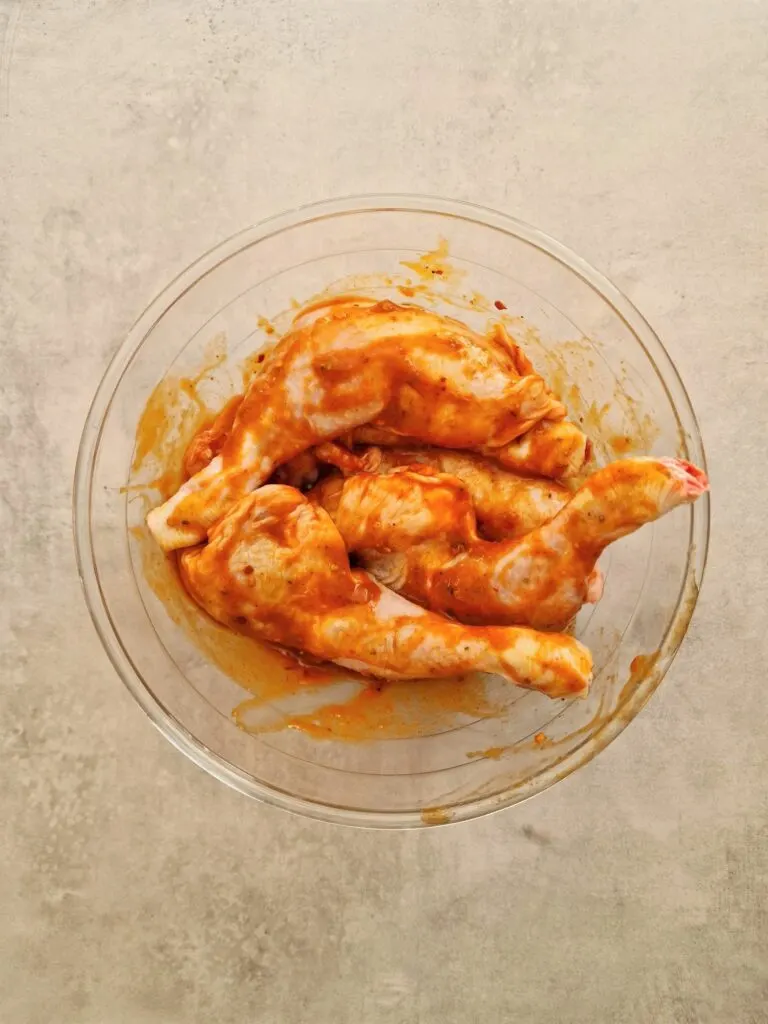 chicken legs marinating in a bowl