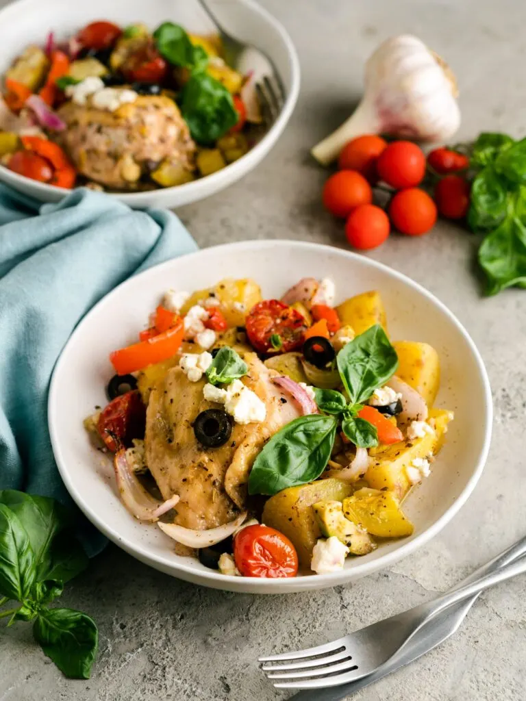 Mediterranean chicken tray bake with fresh basil leaves