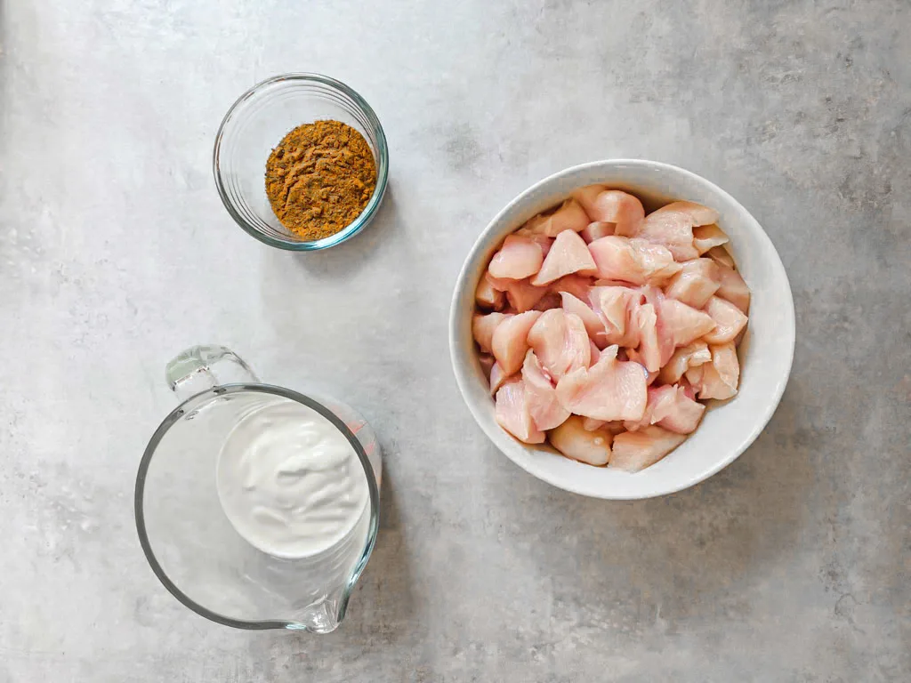 raw chicken breast diced, chicken tikka powder and natural yoghurt to make chicken tikka.