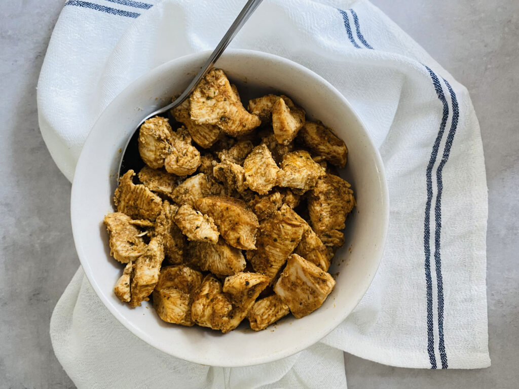 cooked chicken tikka pieces in a bowl with a spoon