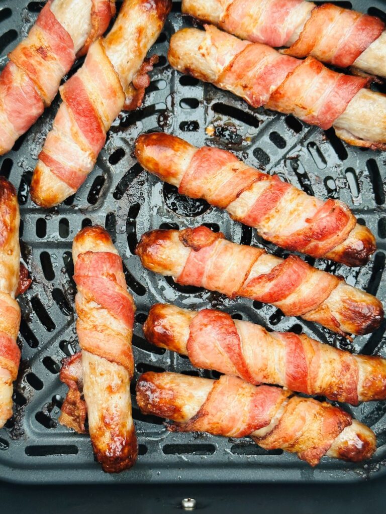 cooked pigs in blankets in an air fryer basket