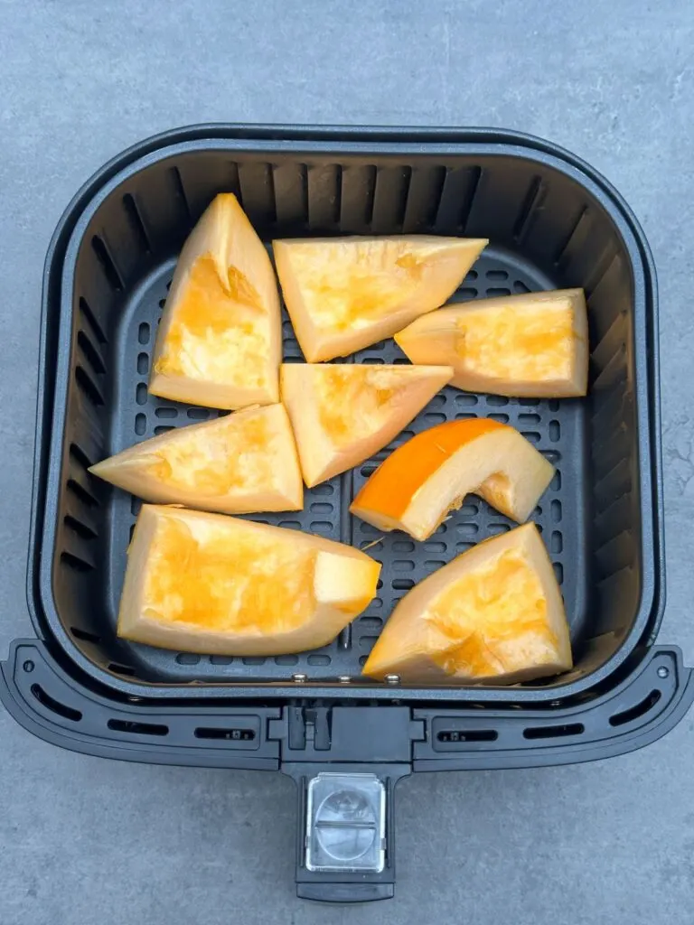 chopped pumpkin in air fryer basket for roasting