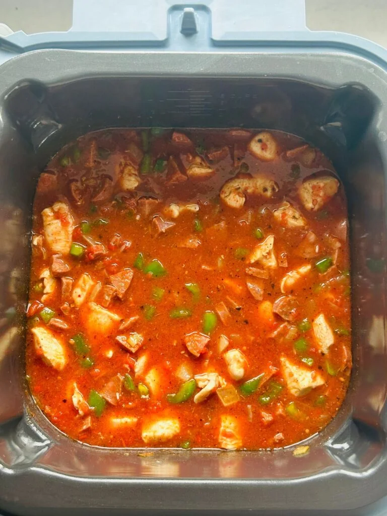 chopped tomatoes added to chicken, peppers, chorizo in a Ninja Speedi pot