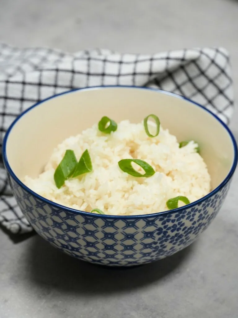 rice cooker coconut rice served in a bowl with spring onions on top
