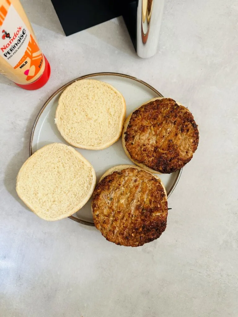 homemade piri piri pork burgers on a bun next to air fryer