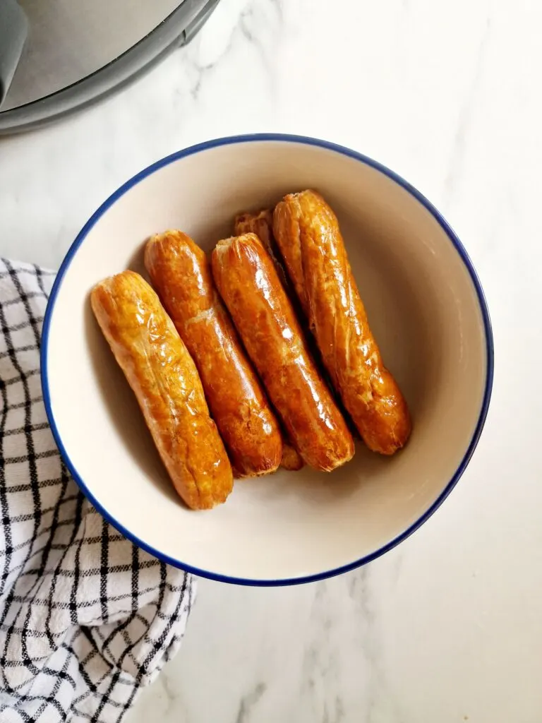 air fryer frozen sausages cooked in a bowl