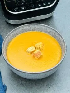 curried carrot soup next to a Ninja soup maker