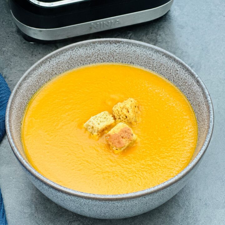 curried carrot soup next to a Ninja soup maker