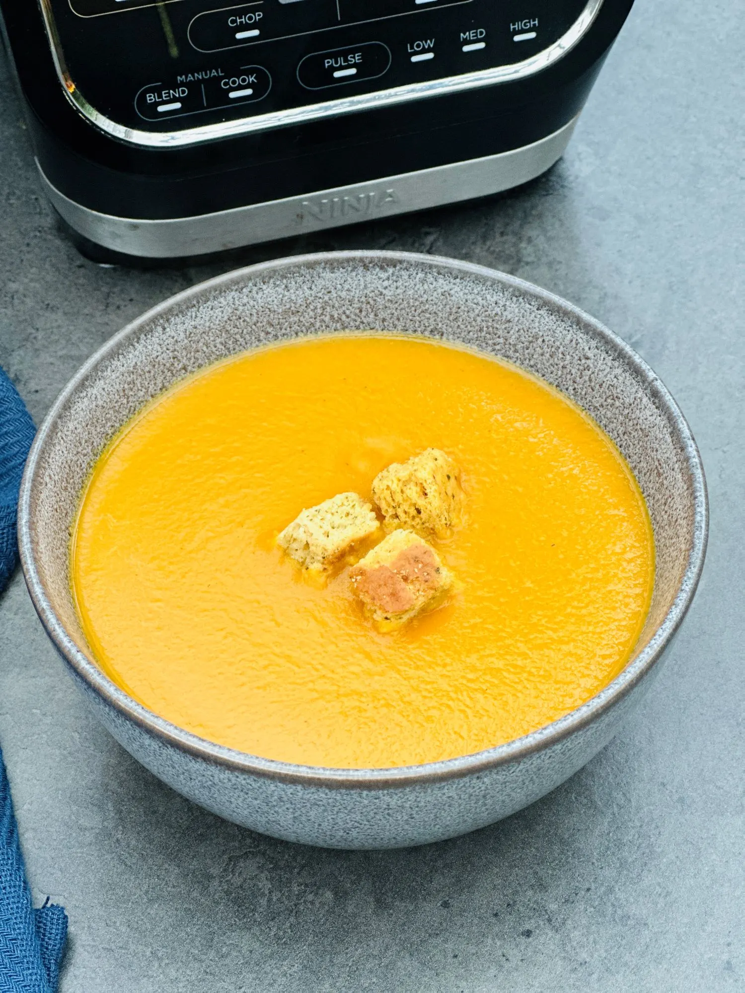 curried carrot soup next to a Ninja soup maker