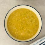 curried lentil and chicken soup in a bowl next to a Ninja soup maker