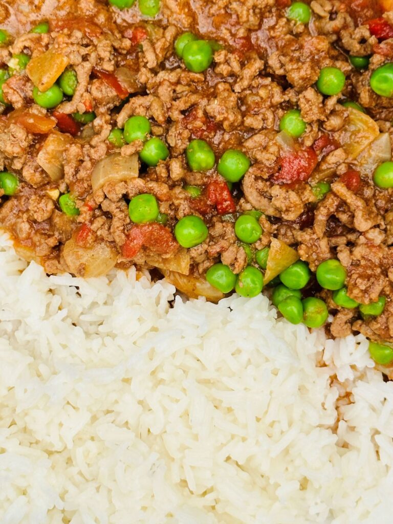 curried mince with peas next to boiled white rice