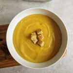 curried parsnip soup in a bowl next to a Ninja Soup maker