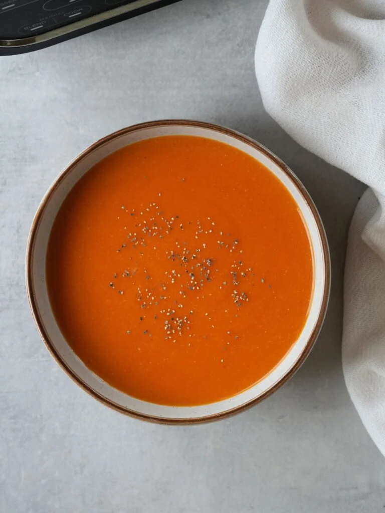 curried red lentil soup with ground black pepper on the top in a bowl