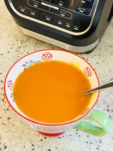 spicy tomato soup next to Ninja soup maker
