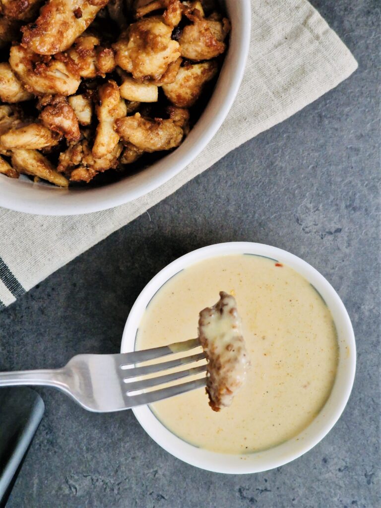 dipping chicken into satay sauce