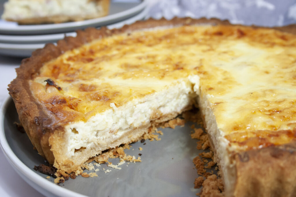 Quiche Lorraine on plate with a slice taken out