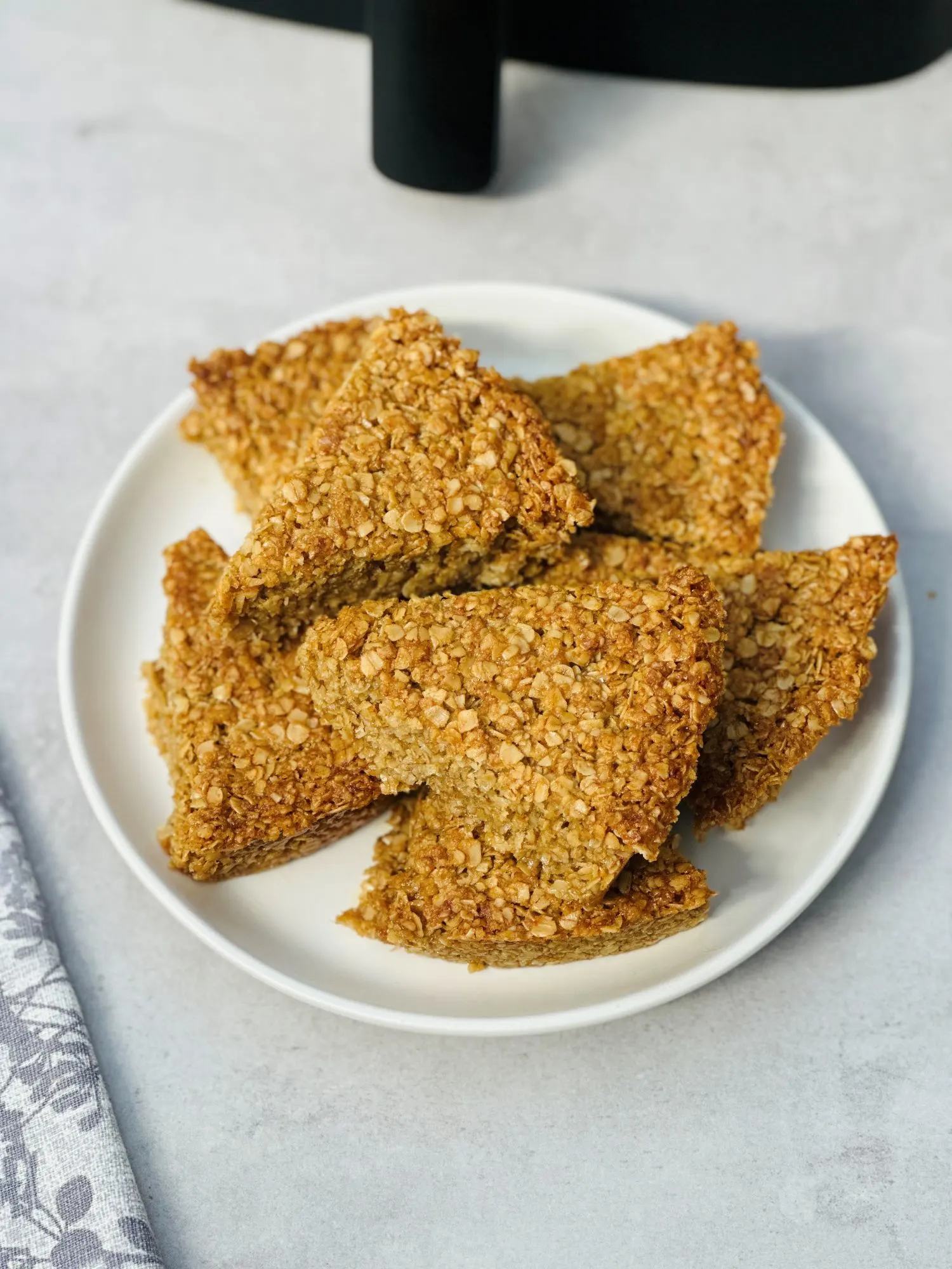 sliced flapjacks on a white plate next to an air fryer