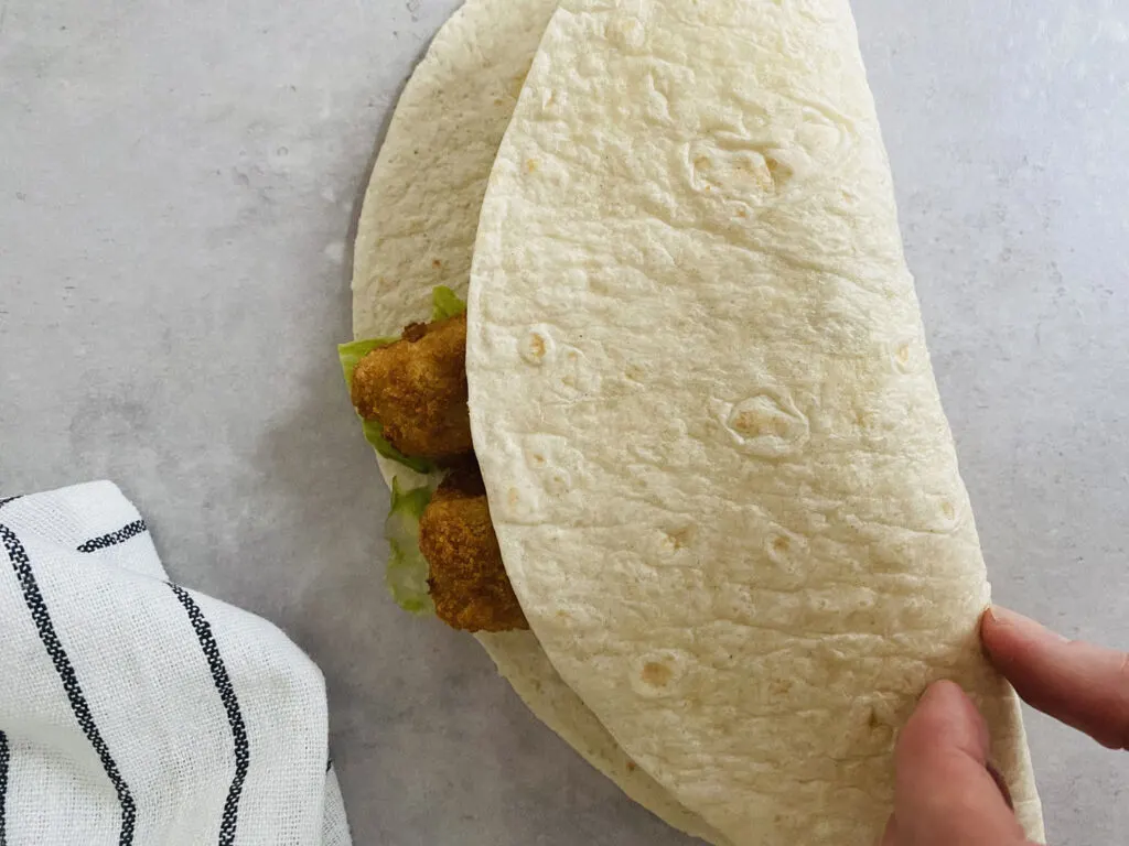 fold tortilla wrap over fish fingers