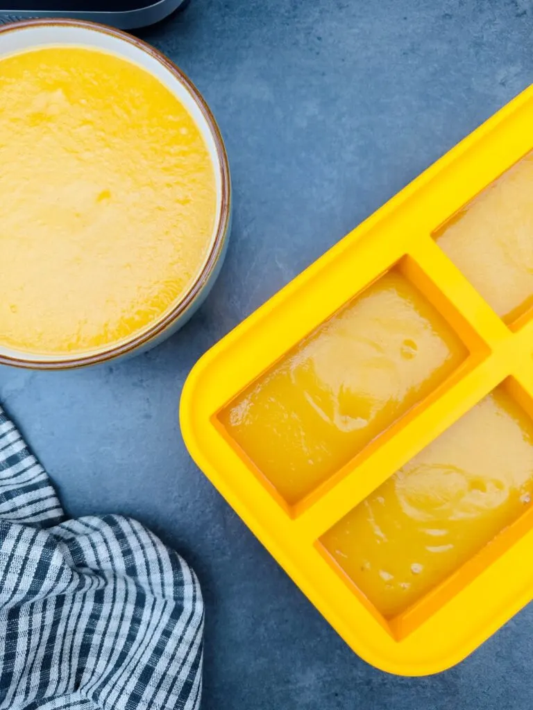 freezing vegetable soup in silicon containers next to bowl of vegetable soup