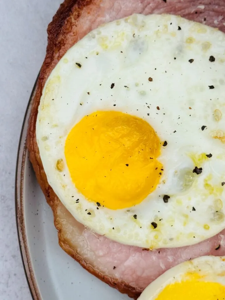 fried egg on gammon with pepper sprinkled on top