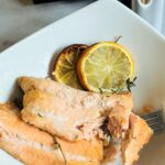 cooked salmon with lemons next to air fryer