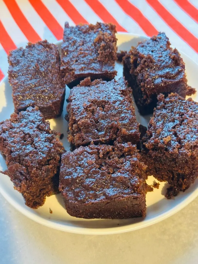 sliced ginger cake on a white plate on top of a red and white cloth