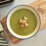 green soup in a bowl next to Ninja soup maker
