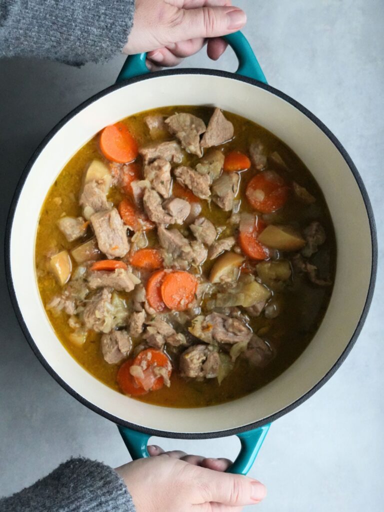 holding a casserole dish with pork cider and apple casserole cooked