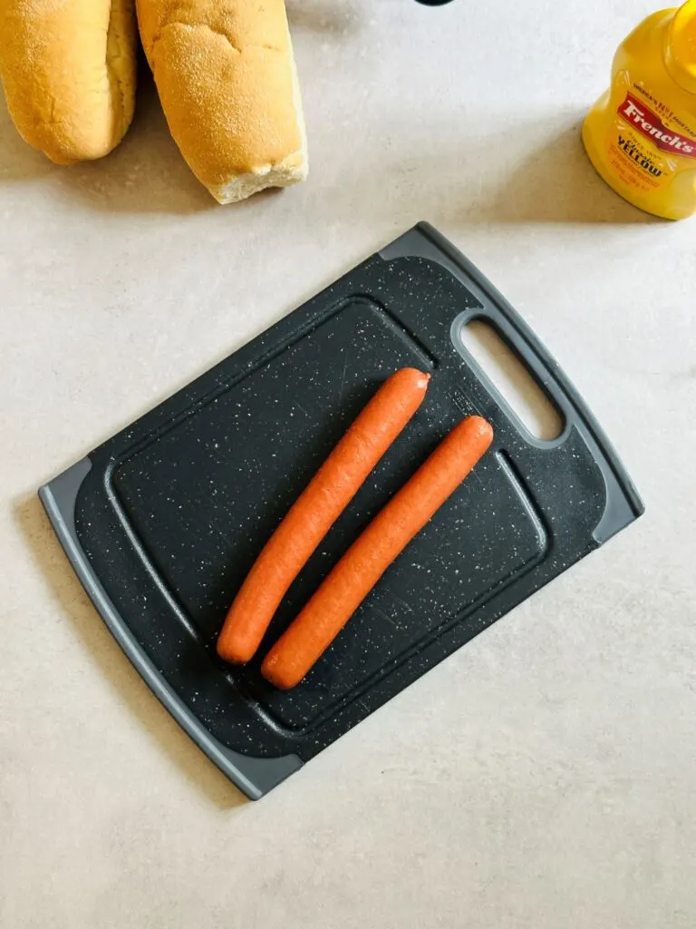 two hot dogs on board preparing for the air fryer