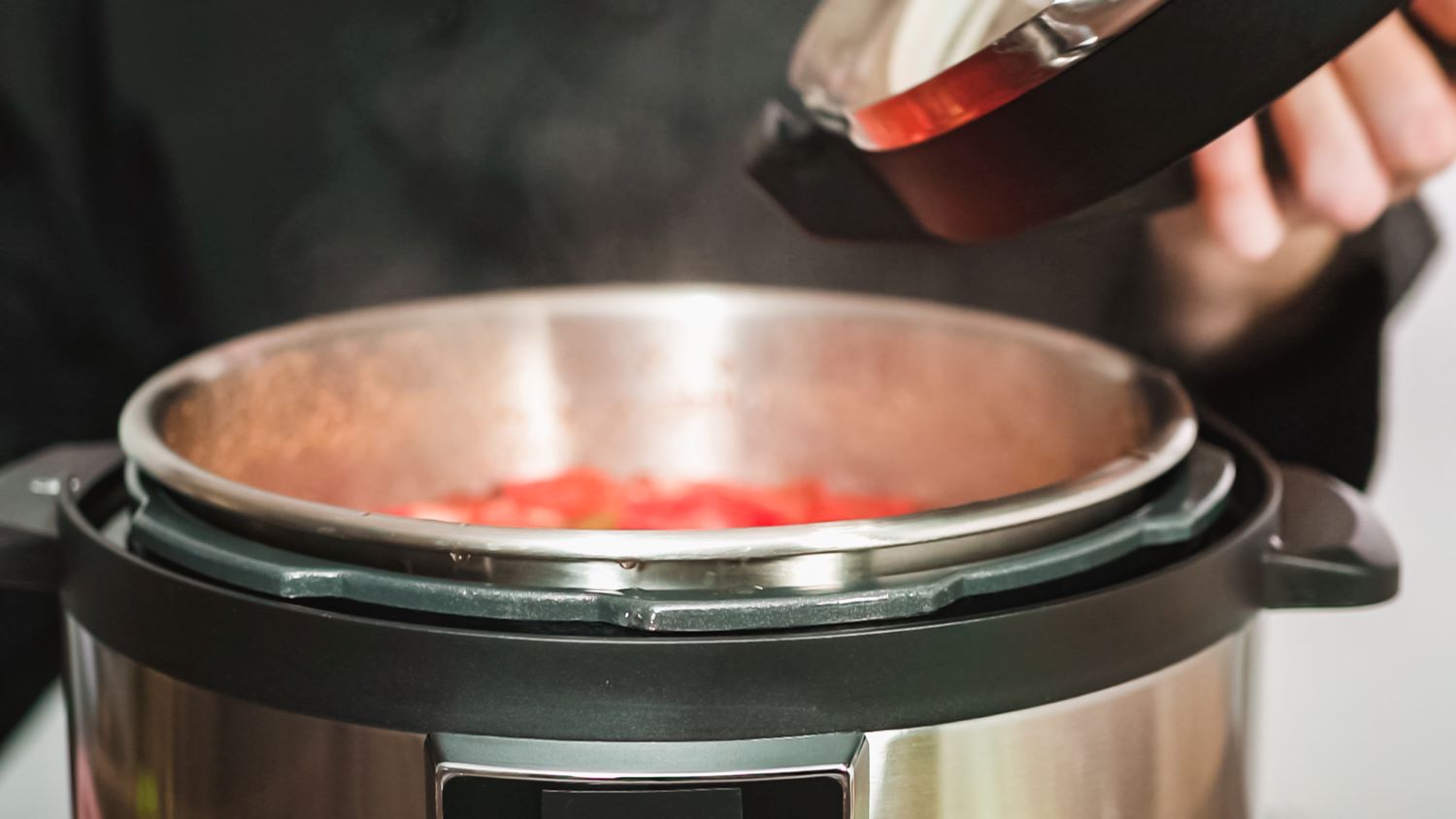 electric pressure cooker with person holding the lid